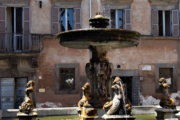 A twisted tailed women fountain in Tuscania.